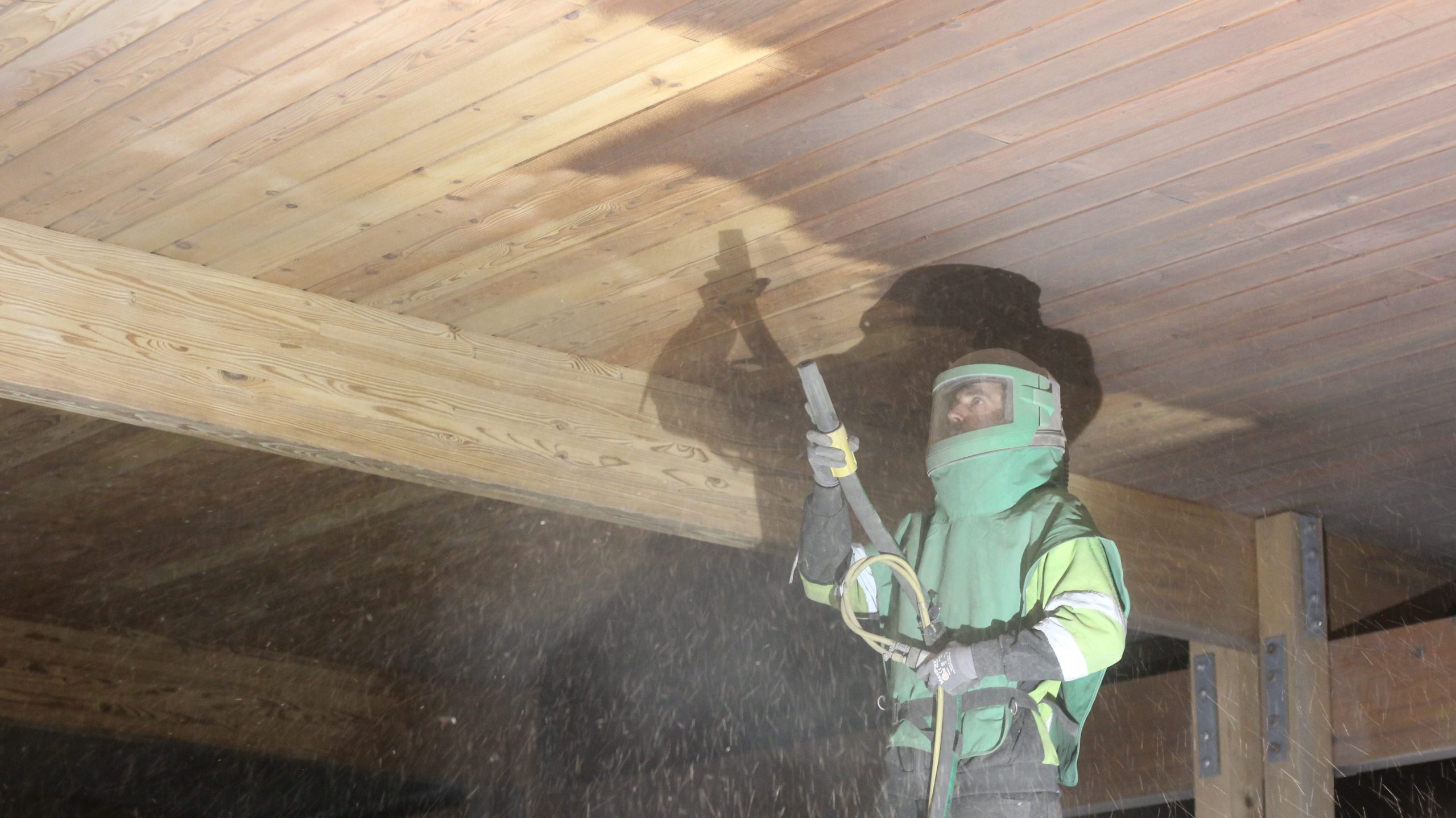 construction worker blasting wood awning