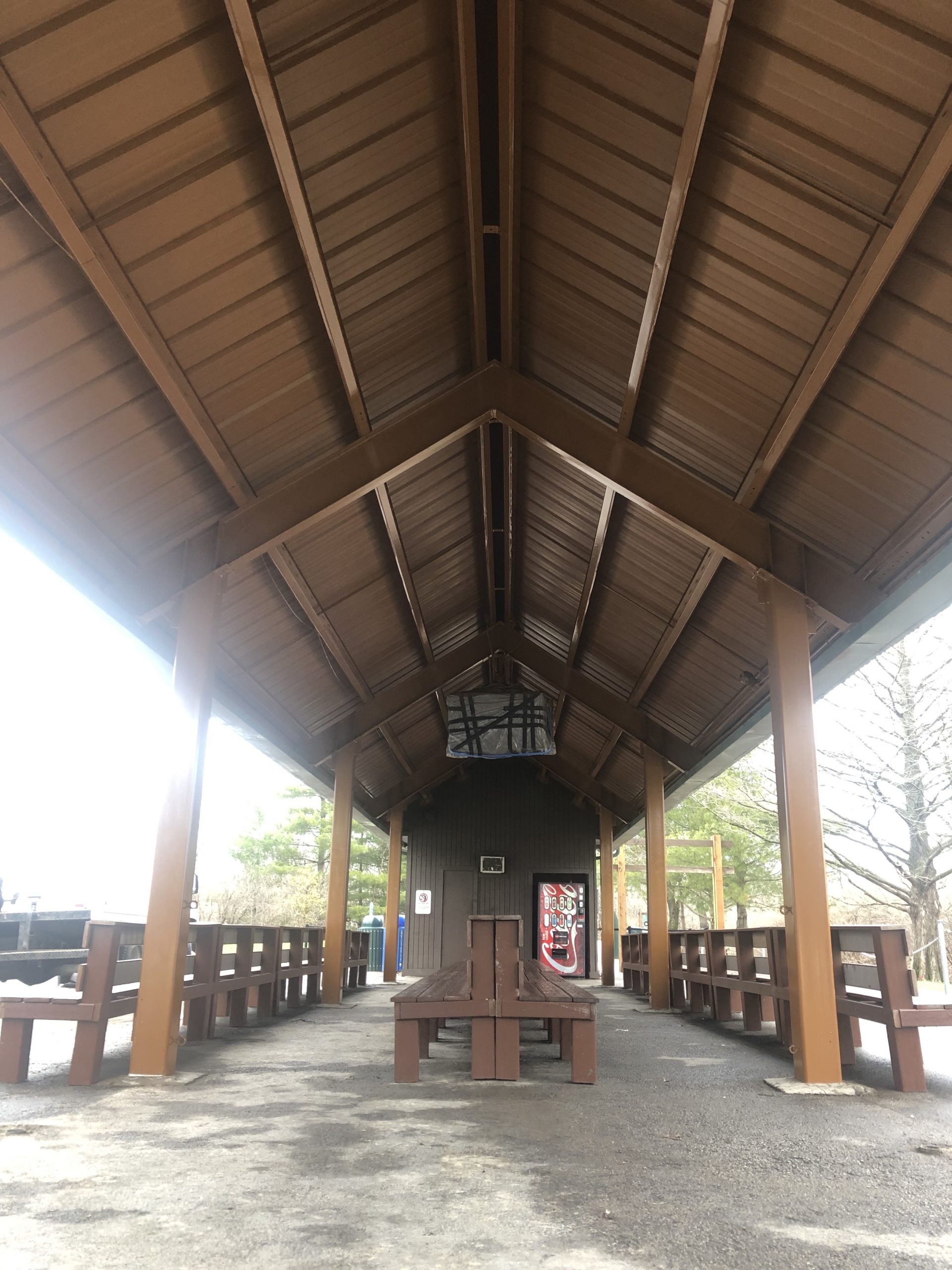 brown awning with benches and soda machine